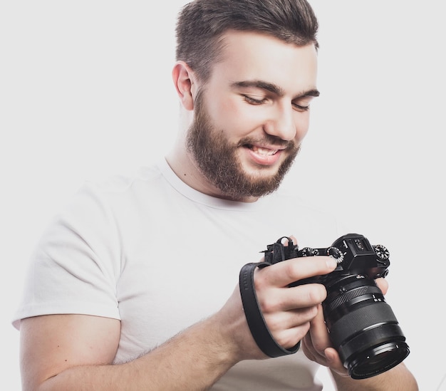 Tecnología de viajes y concepto de estilo de vida joven fotógrafo barbudo tomando fotografías con cámara digital