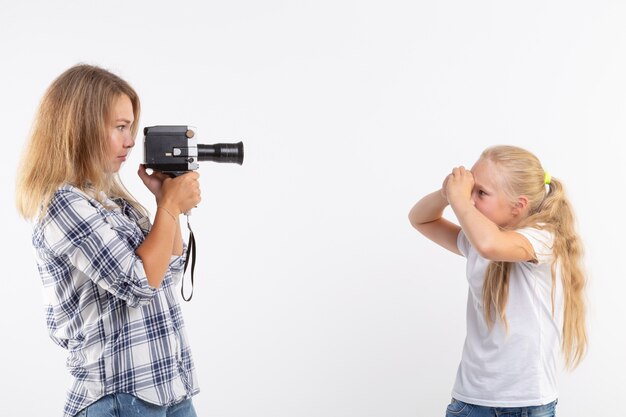 Tecnologías, fotografía y concepto de personas - mujer joven rubia con cámara retro fotografiando