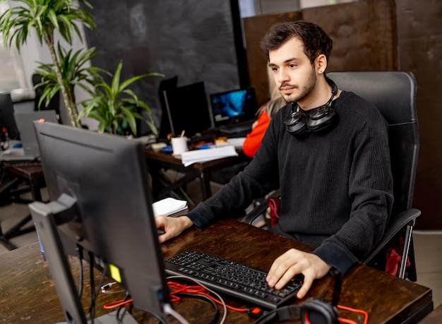 Tecnologías de programación y codificación de diseño de sitios web. Hombre en el trabajo cerca de la computadora. Oficina creativa