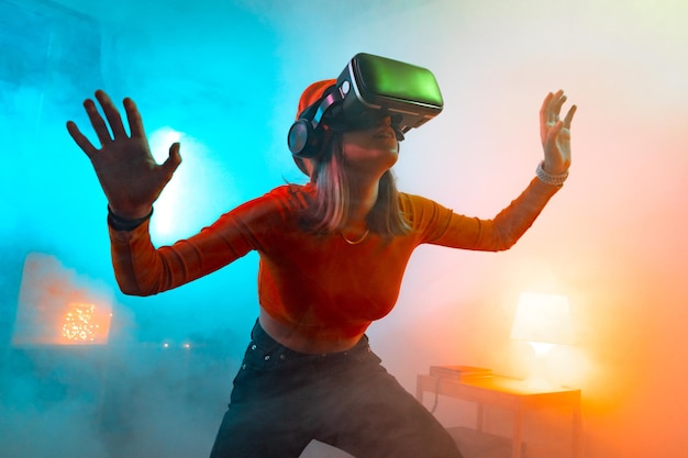 Tecnologias sem fio mulher jovem usando óculos de realidade virtual em um quarto escuro com iluminação neon