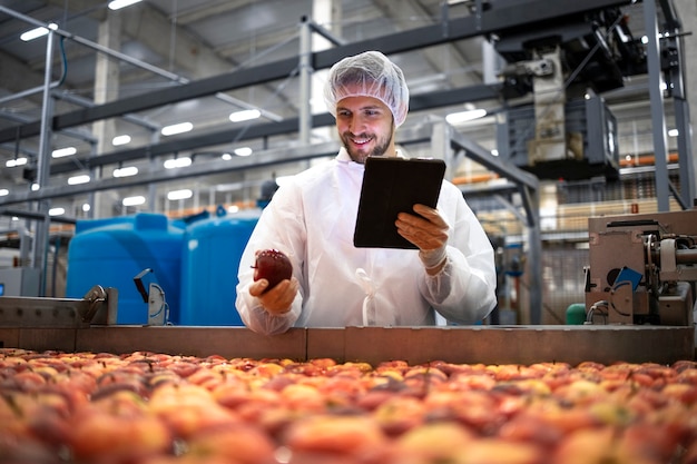 Tecnólogo que realiza el control de calidad de la producción de manzanas en una planta de procesamiento de alimentos.