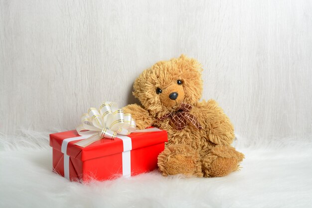 Teddybär auf einem weißen Teppich mit Geschenken