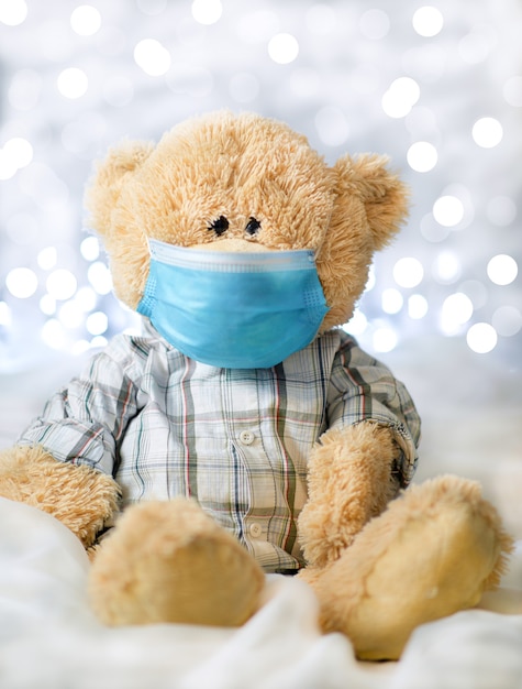 Teddybär im hemd und in der blauen medizinischen maske