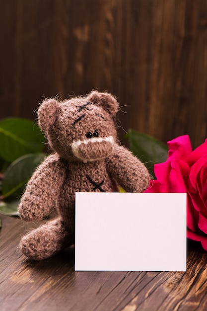 Teddybär mit einer schönen rosa Rose.