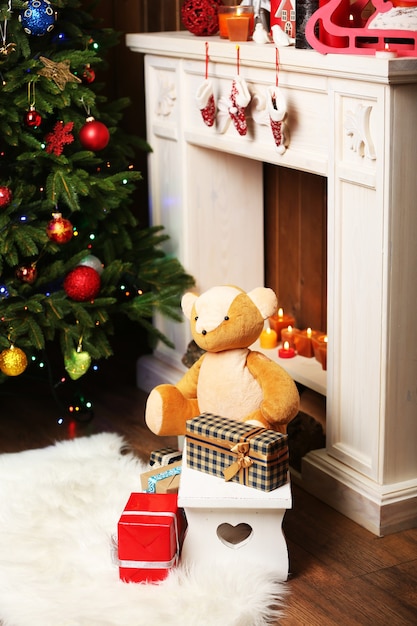 Teddybär mit Weihnachtsgeschenken im Zimmer