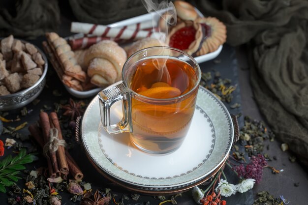 Tee heißes Getränk auf altem Hintergrund in Zusammensetzung auf dem Tisch