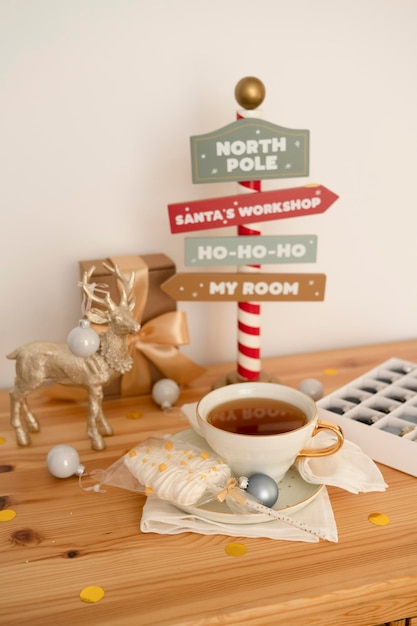 Tee in einer großen weißen Tasse mit Weihnachtsschmuck