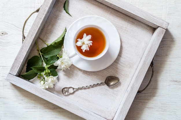 Tee mit Blume auf Holztisch