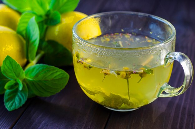 Tee mit Zitrone und Minze in einer transparenten Glasschale auf dem Tisch