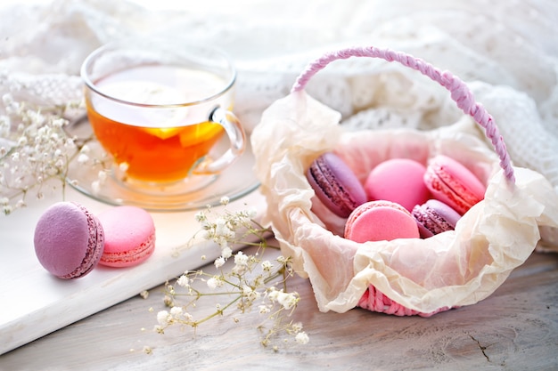 Tee mit zitrone, wilden blumen und macaron auf weißem holztisch.