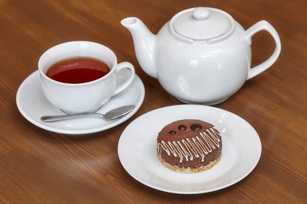 Tee und runder Schokoladenkuchen auf Platte