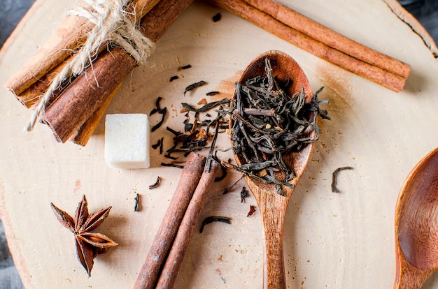 Teeblätter und getrockneter Tee auf einem hölzernen