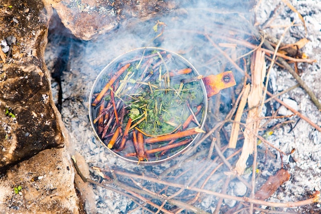 Teegetränk am Feuer in freier Wildbahn kochen