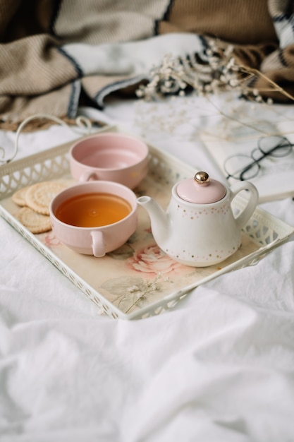 Teekanne mit Tee und Tassen auf einem Tablett