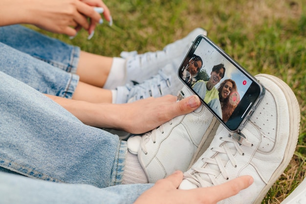 Teenager-Beine, die ein Telefon halten und verschiedene virale Videos filmen Beliebtes soziales Netzwerk im Internet