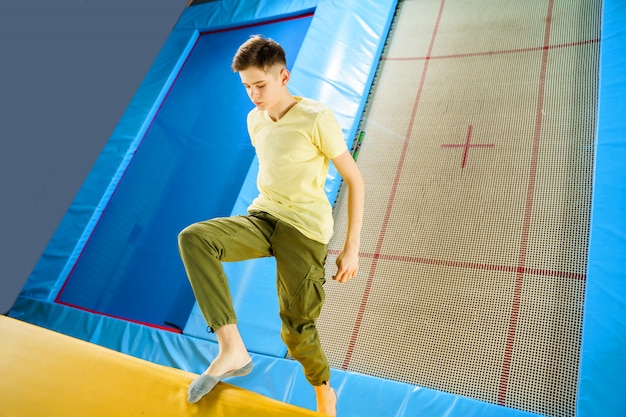 Teenager, der auf Trampolinpark im Sportzentrum springt