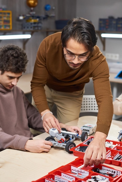 Teenager, der mit seinem Lehrer einen Roboter baut