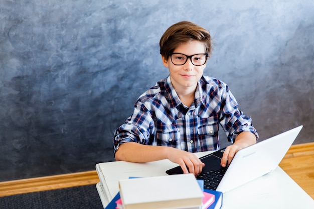 Foto teenager, der zu hause am laptop arbeitet