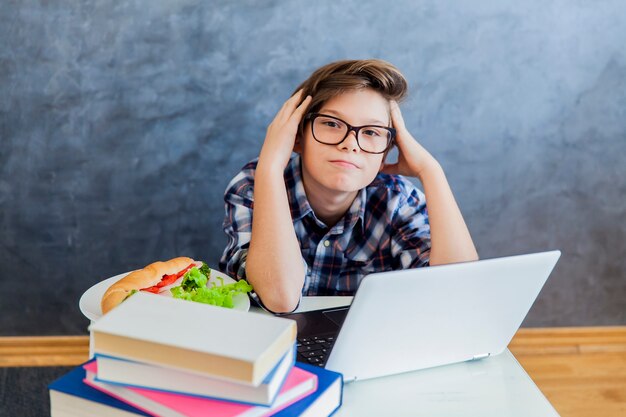 Teenager, der zu Hause am Laptop arbeitet