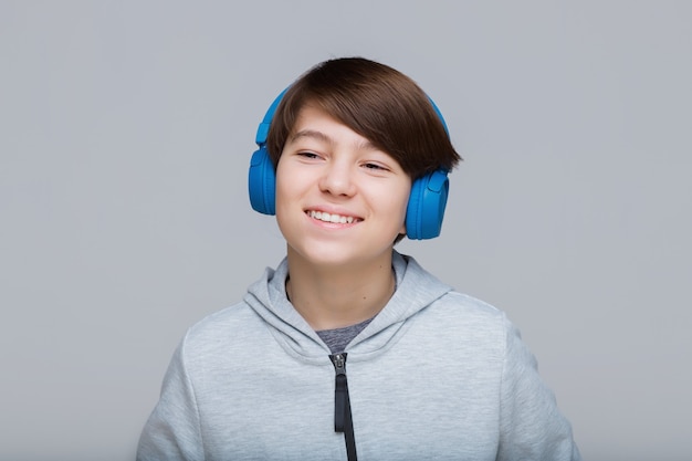 Teenager in blauen Kopfhörern, die Musik hören