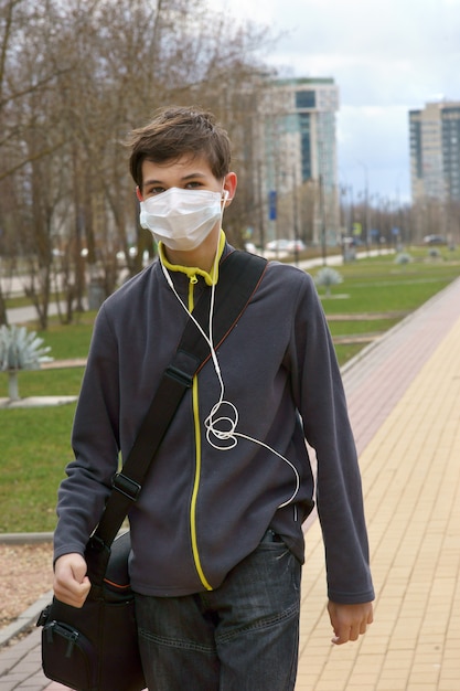 Foto teenager in einer medizinischen maske auf der straße in der stadt