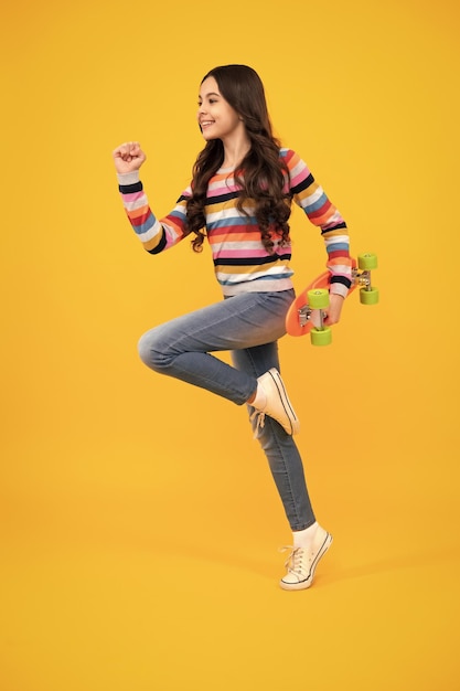 Teenager Jugend lässig Kultur Teen Mädchen mit Skateboard über isolierte Studio-Hintergrund Teenager in Mode stilvolle Kleidung Glücklicher Teenager positive und lächelnde Emotionen von Teenager-Mädchen