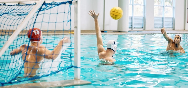 Teenager-Jungen und Team-Wasserpolo und Spiel mit Sport-Action und Energie im Indoor-Schwimmbad Junge männliche Spieler Highschool-Athletengruppe und Wettbewerb mit Fitness und Teamarbeit