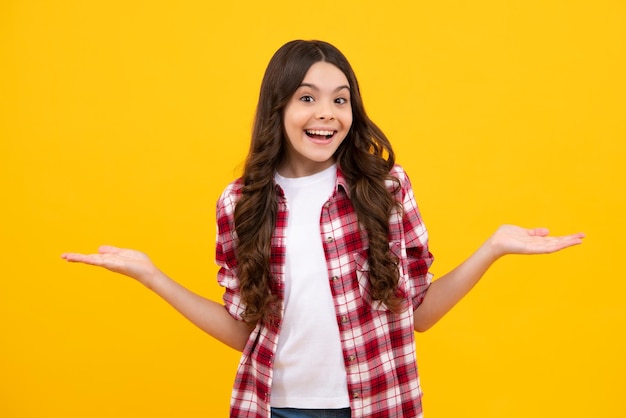 Teenager-Kind, das mit einem Finger auf die Seite zeigt, um ein Produkt oder eine Idee zu präsentieren Teen-Mädchen in lässigem Outfit, das auf leeren Raum zeigt Glücklicher Teenager, positive und lächelnde Emotionen von Teenager-Mädchen