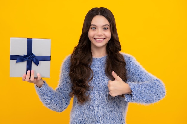 Teenager-Kind im Winter tragen Geschenkboxen, die ein frohes neues Jahr oder Weihnachten feiern Winterkinderurlaub Glücklicher Teenager positive und lächelnde Gefühle von Teenager-Mädchen