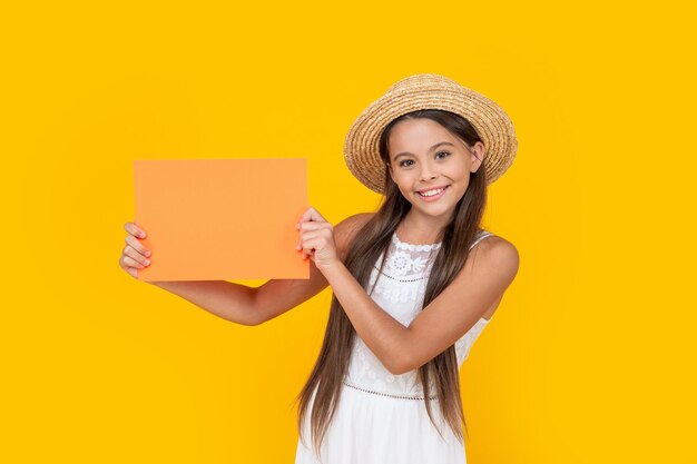 Teenager-Kind lächelt mit Kopierraum auf orangefarbenem Papier auf gelbem Hintergrund