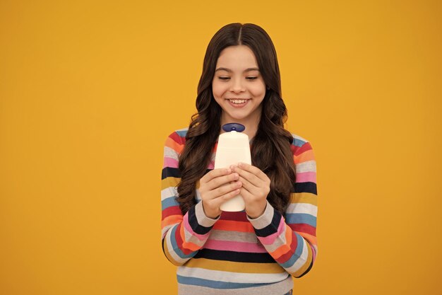 Teenager-Kind-Mädchen mit Flasche Shampoo-Behälter oder Duschgel Kinder Haarpflege Haarkosmetik