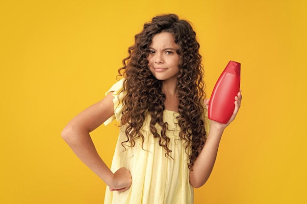Teenager Kind Mädchen zeigt Flasche Shampoo Conditioner oder Duschgel Haarkosmetikprodukt Flasche für Werbespots für Kopienraum