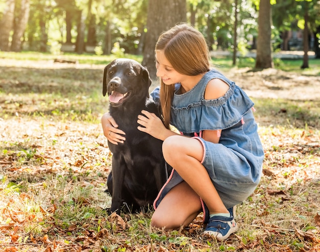 Teenager lächelnd und einen Hund umarmend