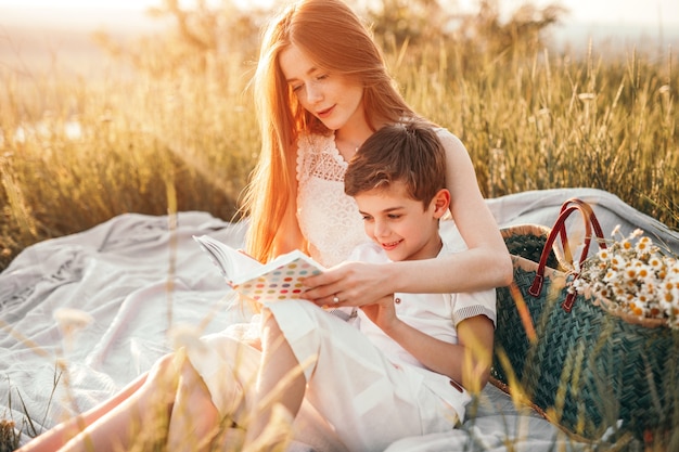 Teenager lächelt und liest Buch zum glücklichen Bruder