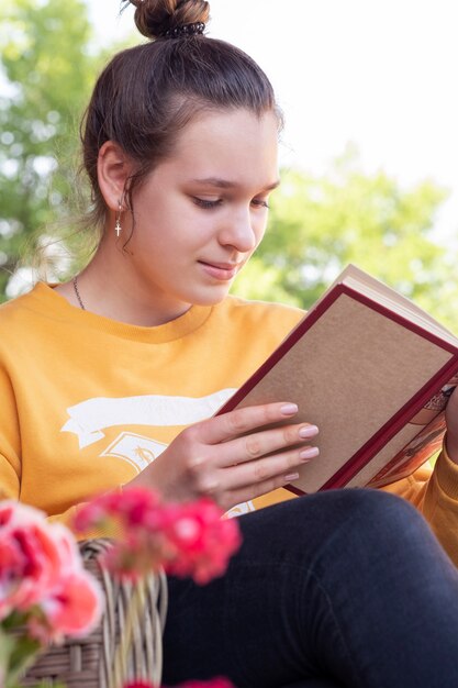 Foto teenager liest buch im garten