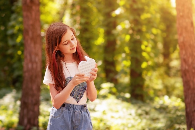 Teenager-Mädchen auf dem Hintergrund der Natur des Waldes Das Mädchen in einem weißen T-Shirt