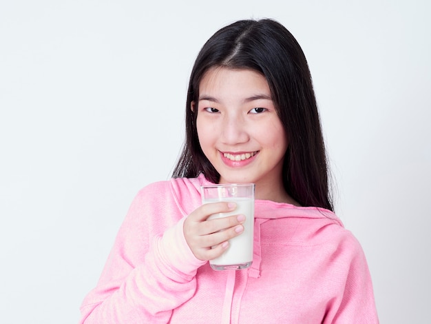 Teenager-Mädchen, das ein Glas Milch hält.