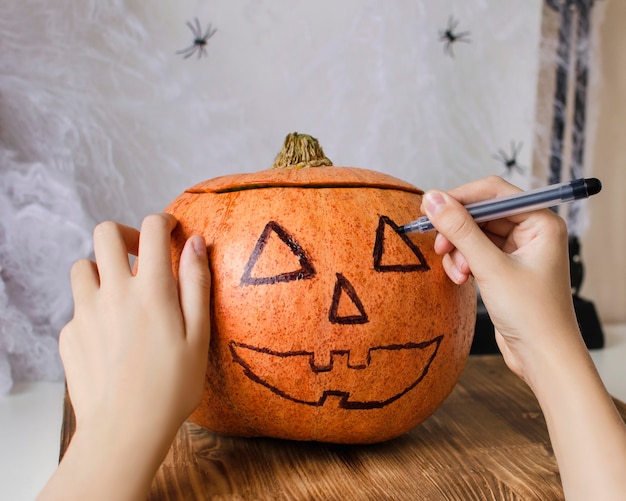 Foto teenager-mädchen, das einen halloween-kürbiskopf macht. dekoration und feiertagskonzept