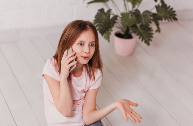 Teenager-Mädchen, das emotional am Telefon spricht und gestikuliert