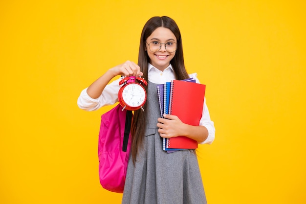 Teenager-Mädchen der Schule, das Zeit überprüft Schulmädchen mit Wecker Schulzeit