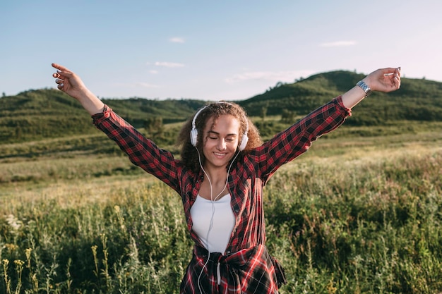 Foto teenager-mädchen hört musik mit kopfhörern in der natur