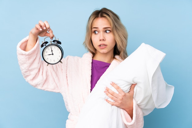 Teenager-Mädchen im Pyjama auf blauer Wand