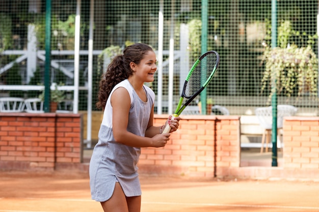 Teenager-Mädchen im sportlichen Outfit, das Tennis spielt