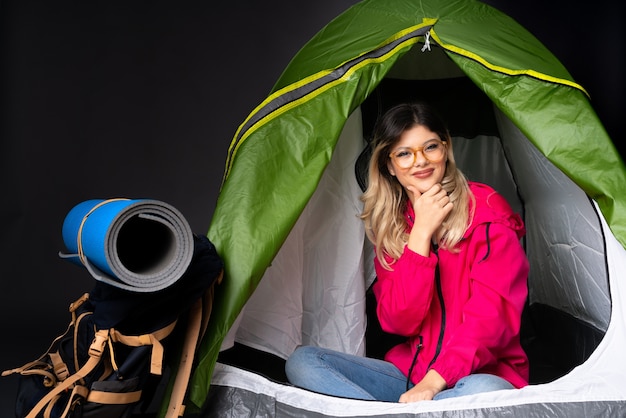 Teenager-Mädchen in einem grünen Zelt des Campings