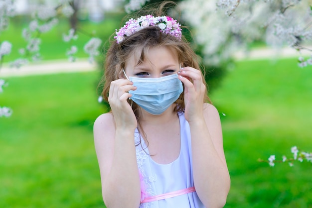Teenager-Mädchen in einer medizinischen Maske im Garten