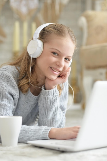 Teenager-Mädchen in Kopfhörern mit Laptop