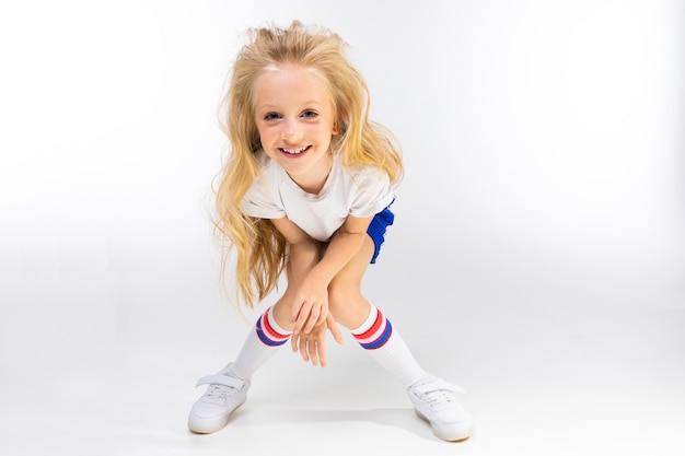 Teenager-Mädchen in Sportbekleidung auf einem weißen Hintergrund mit Kopienraum.