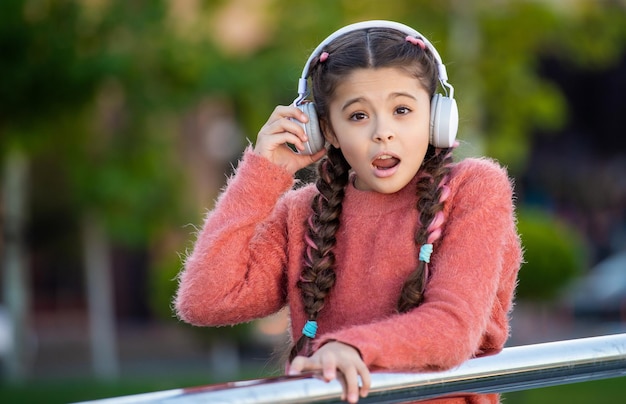 Teenager-Mädchen kann wegen Musik nicht gut hören Teenager nimmt Kopfhörer ab, um Musik zu hören