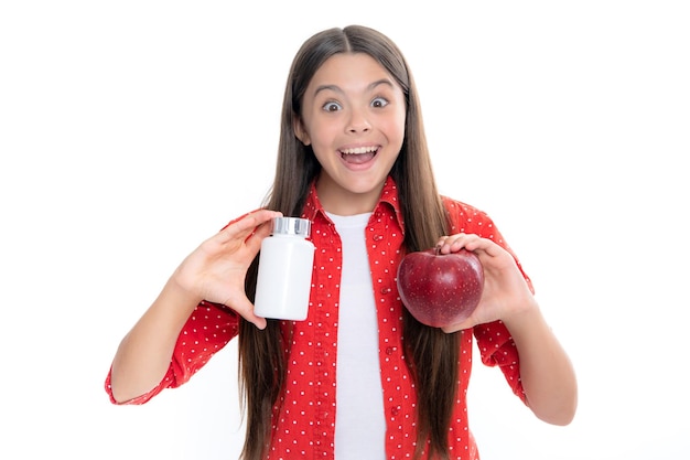 Teenager-Mädchen mit Apfel und natürlichen Lebensmittelzusatzstoffen oder Vitaminpillen gesunder Lebensstil Präsentieren von Tabletten in Kapselform für Kinder Porträt eines emotional erstaunten, aufgeregten Teenager-Mädchens