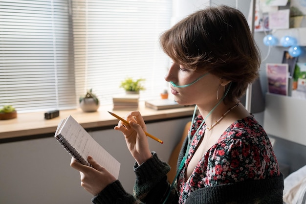 Teenager-Mädchen mit Bleistift, die ihre Notizen im Notizbuch durchsieht